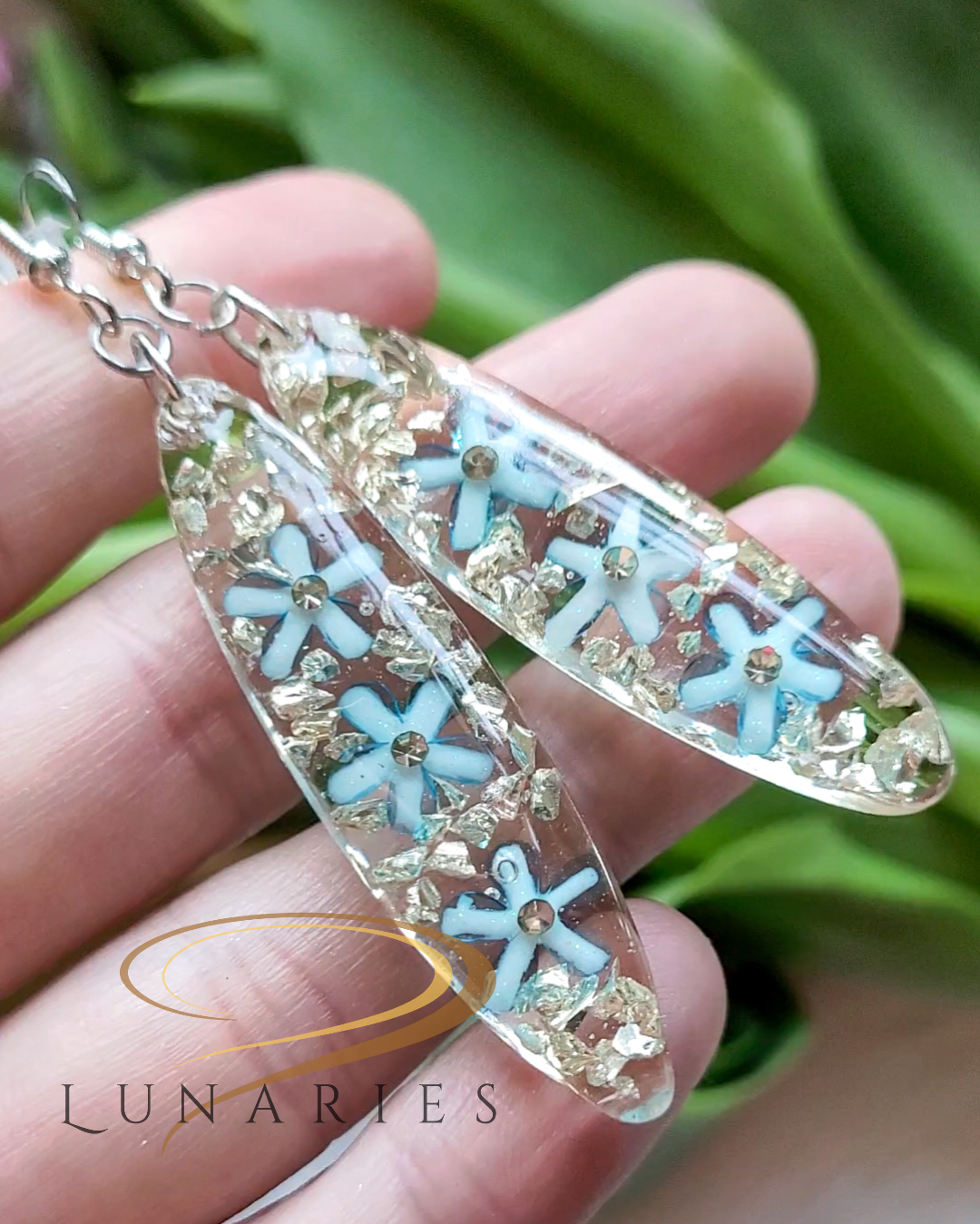 Clear resin earring with blue flowers and silver rhinestones