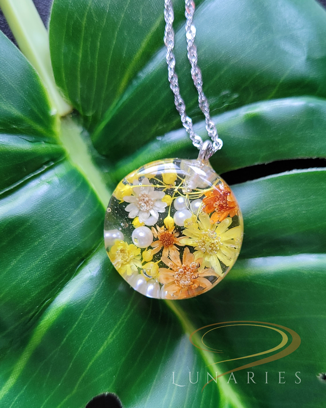 clear resin pendant with yellow dried flowers