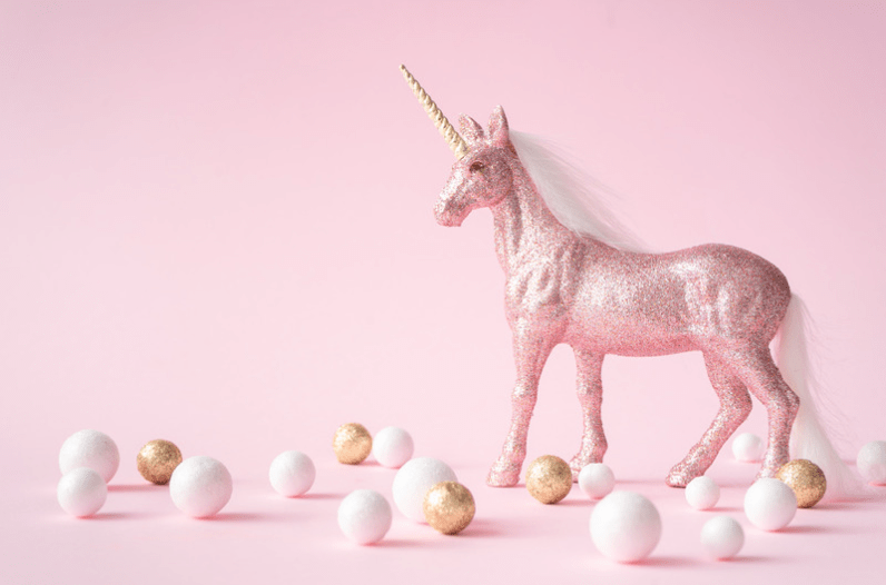 Glittery pink unicorn on a pink background, with white, gold, and pink spheres