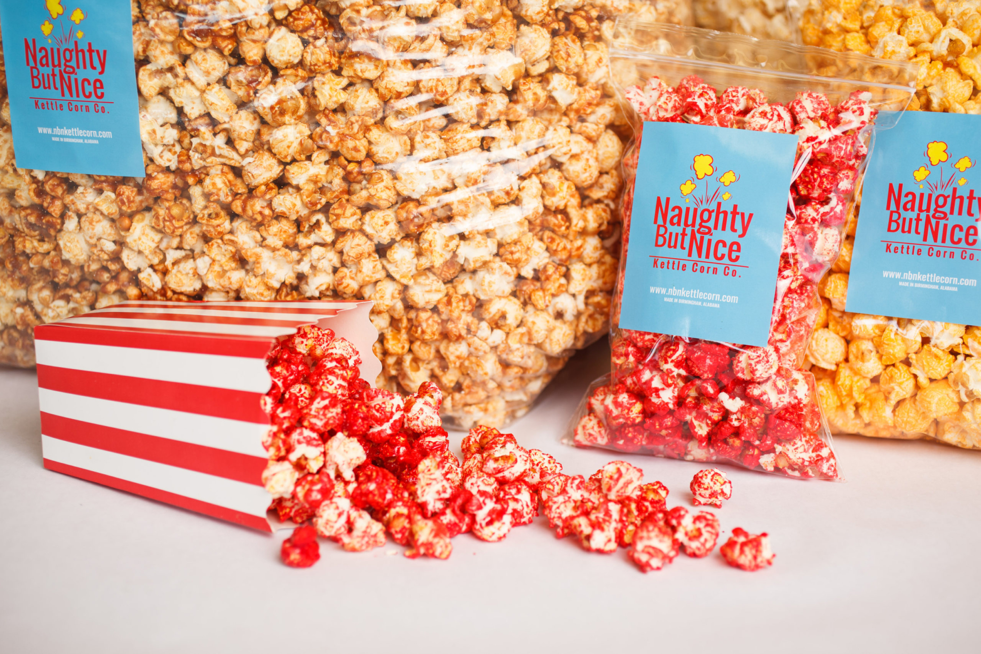 Naughty But Nice Kettle Corn Company showing bags of popcorn spilling out
