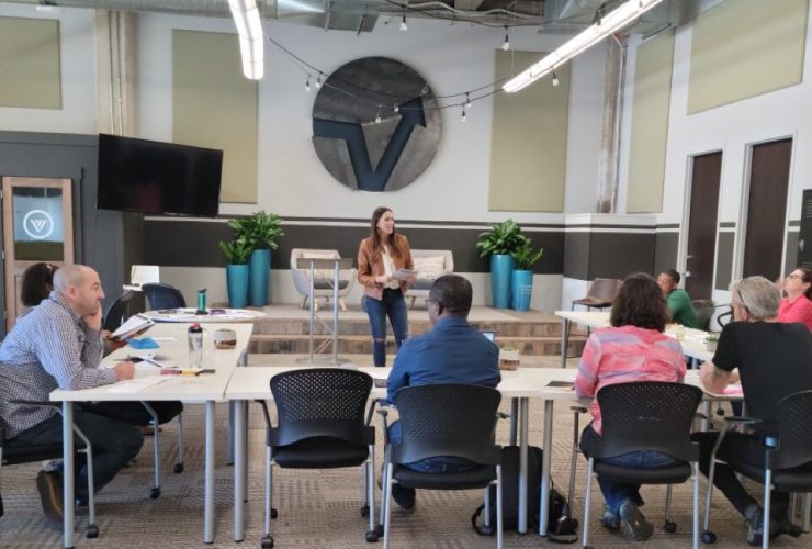 Kelli facilitating a workshop for a group of founders surrounding a conference table