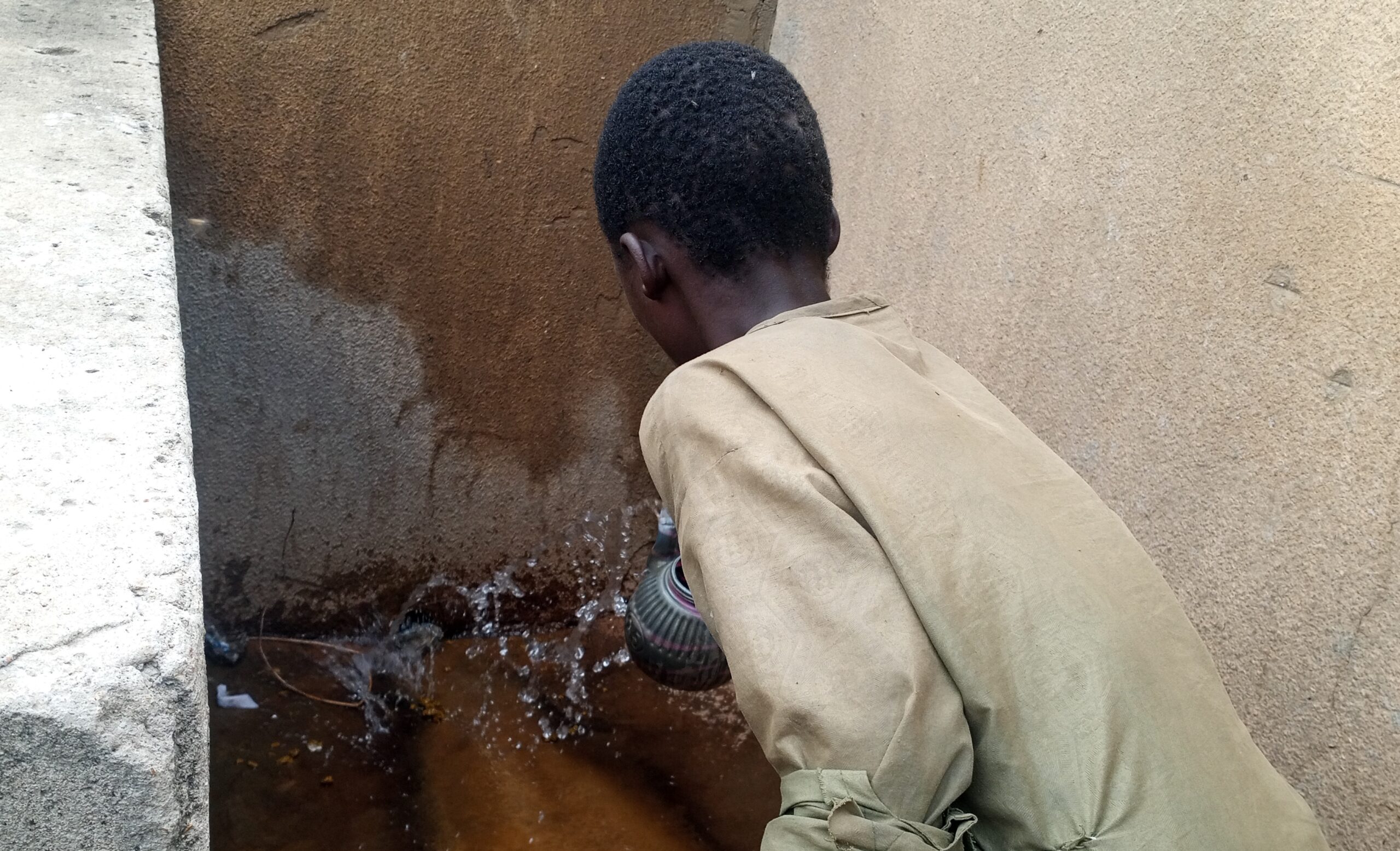 Image of a boy washing off his faeces into drainage at Investigate Motor Park Dutse Photo Credit Sunday AwosoroDUBAWA