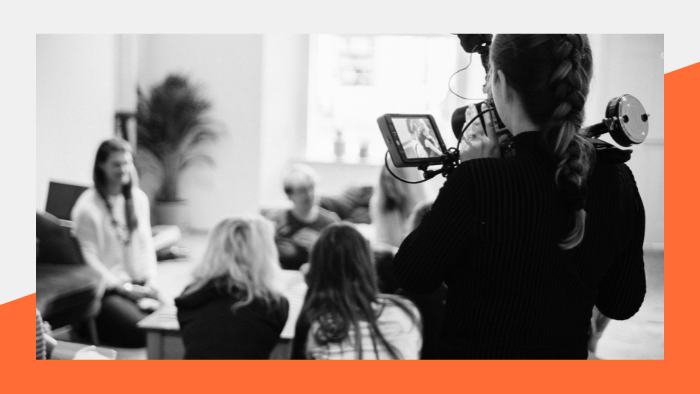 Woman filming a group of people talking