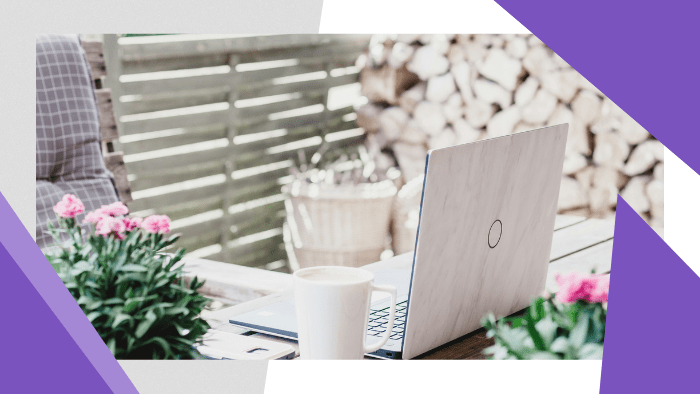 Laptop and coffee mug set on a table on a patio