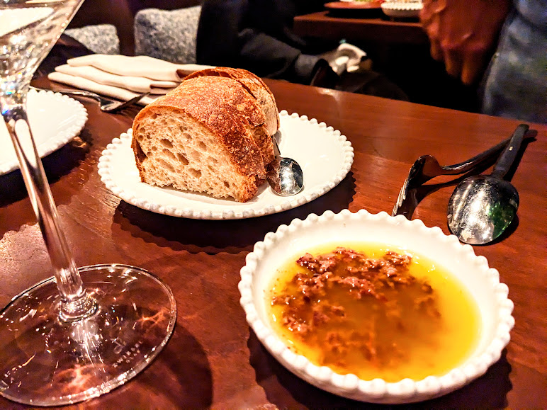 A plate of bread and a glass of wine on a table at Barberio Osteria.