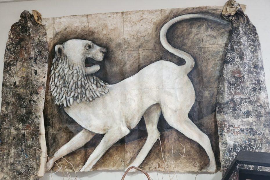 A painting of a lion hanging on a wall.