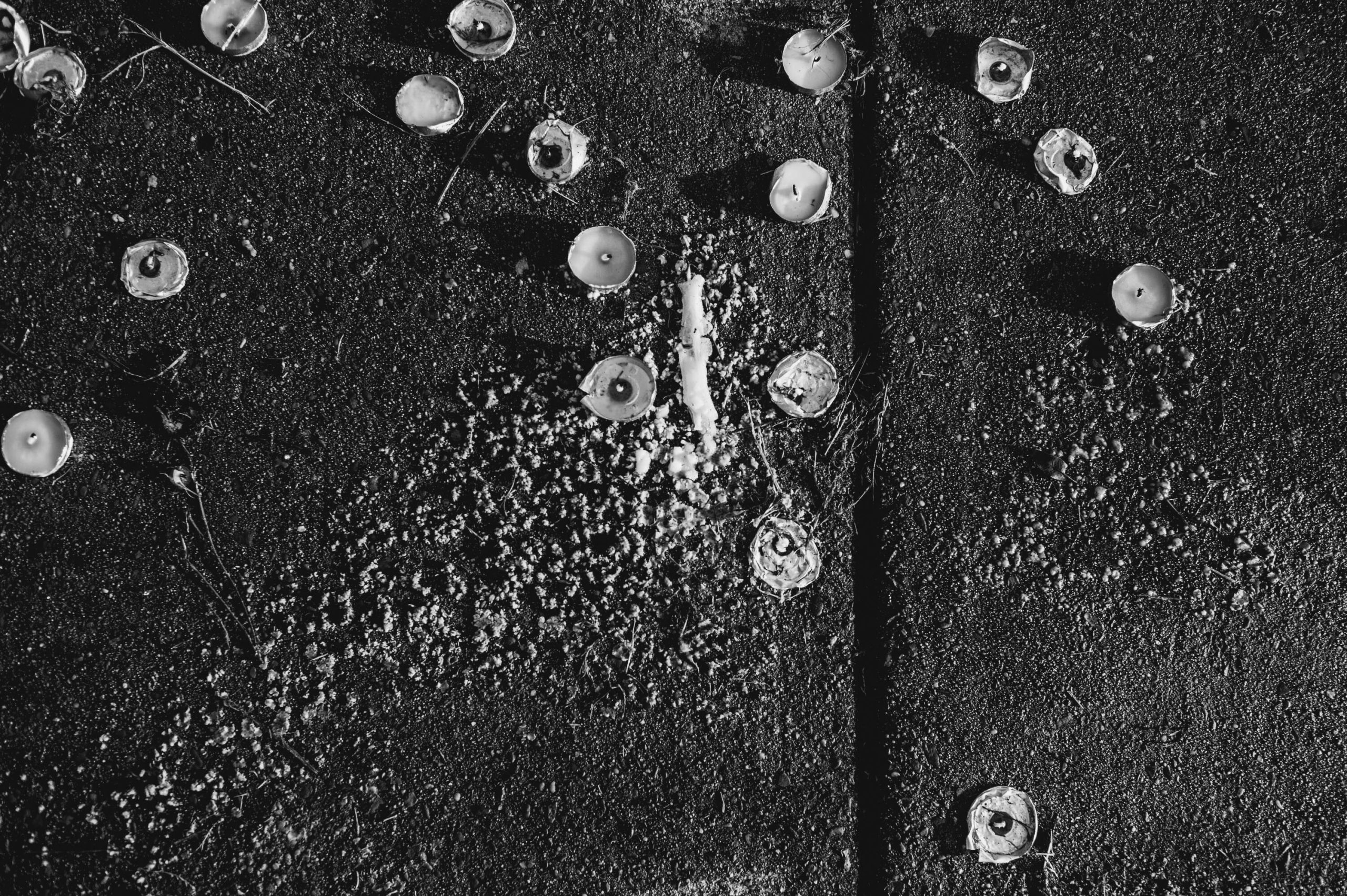 Black and white image of tea lights on a sidewalk