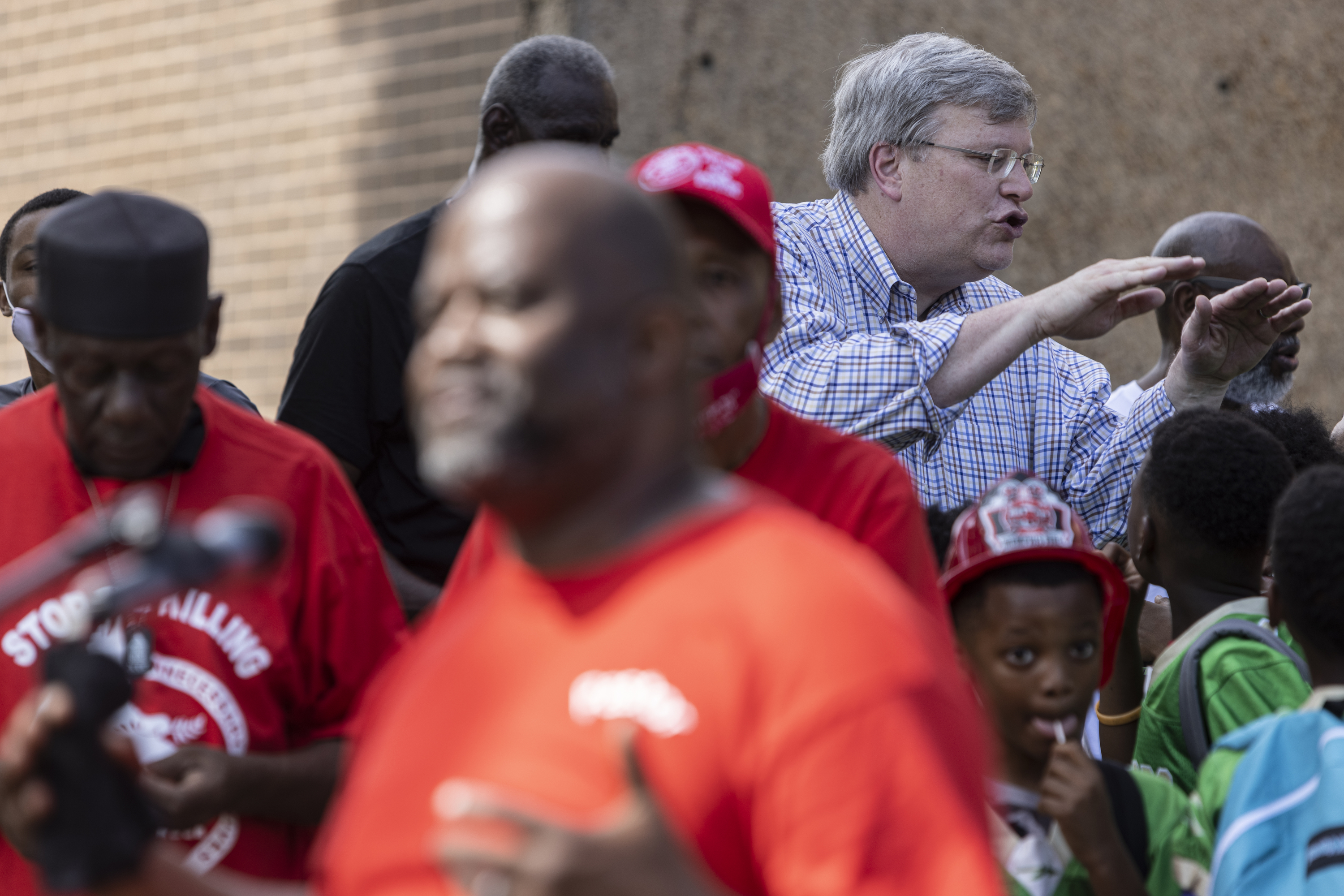 Jim Strickland talks to a group of young Black boys at an event. 