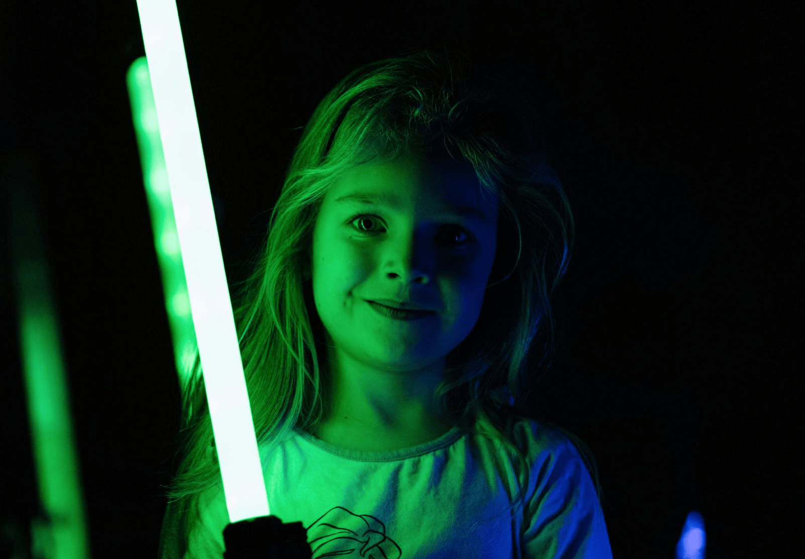 girl holding green lightsaber star wars day weekend family fun