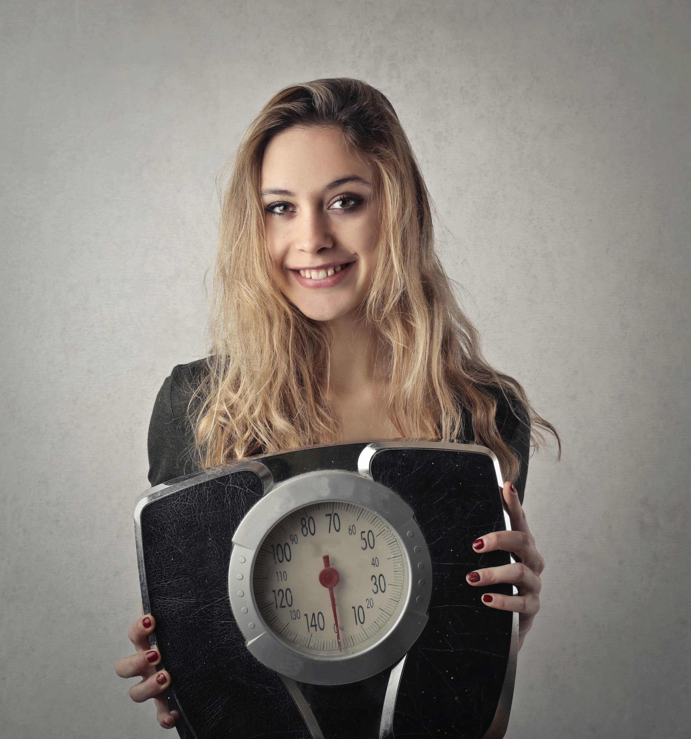 Girl holding a weighing machine