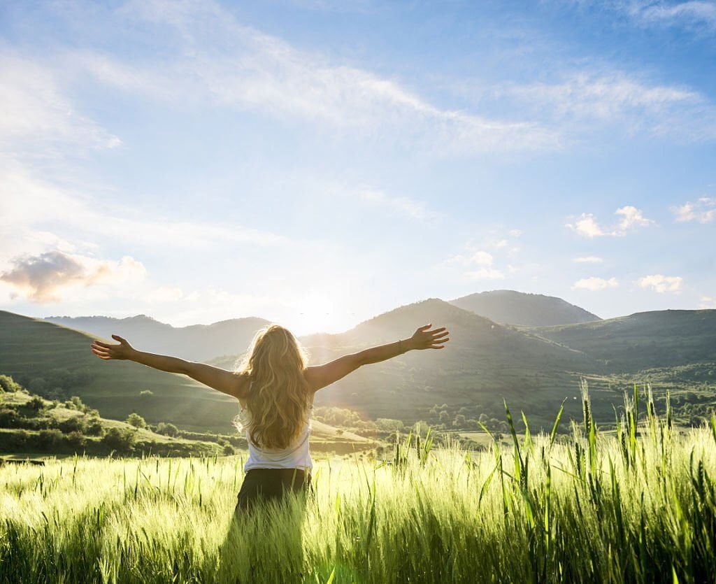 More joy in life - joyful woman in a field