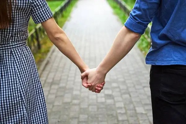 Couples holding hands in a parkway - dating rules book