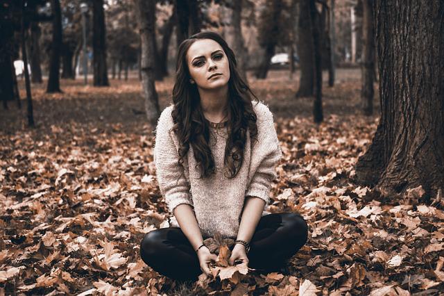 Failed and sad woman sitting on the forest floor