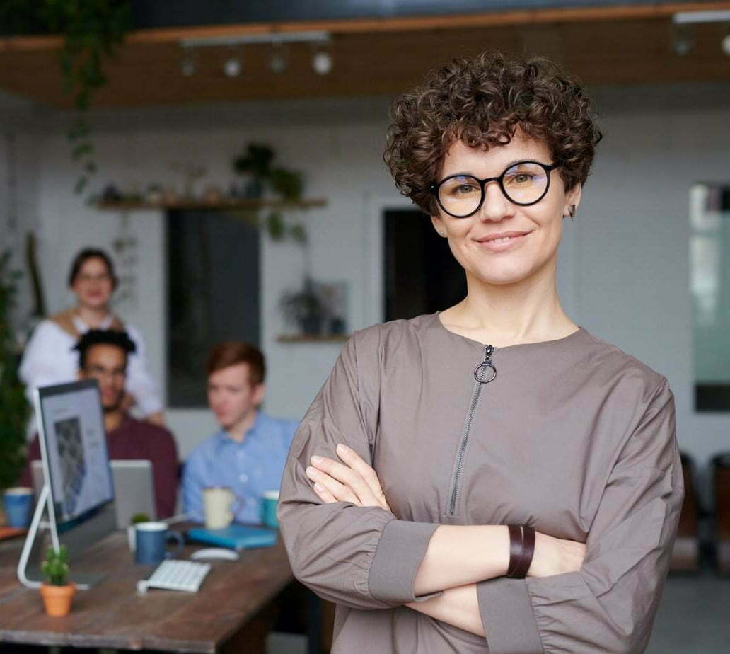 Manager lady smiling with employees in the background