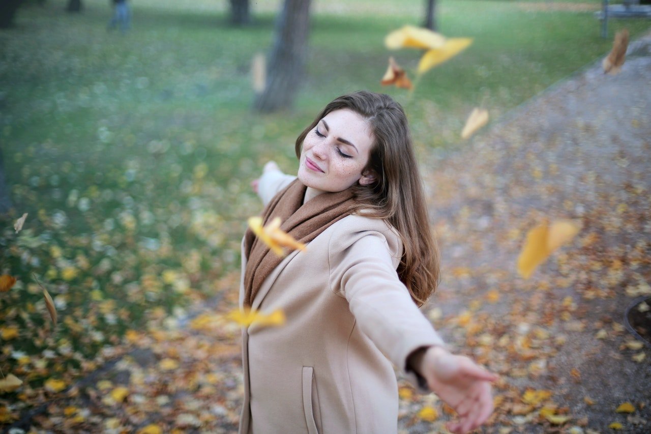 Happy woman in park enjoying pleasure goal achievement