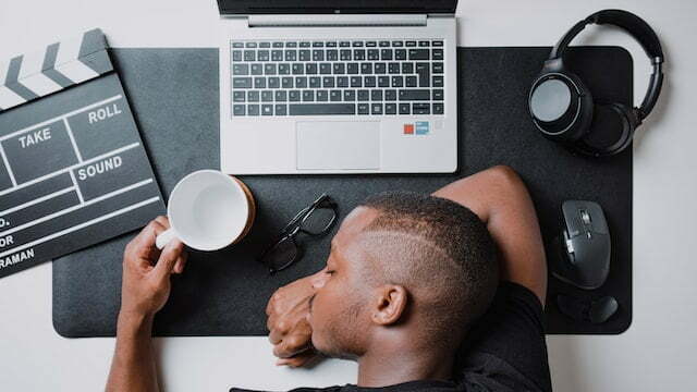 Man napping on his desk with silver laptop types of procrastination