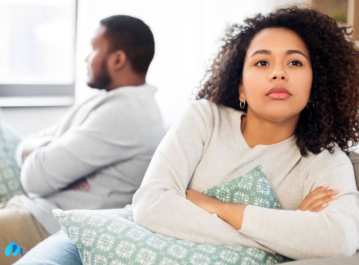 Moody couple sitting on sofa after an argument-handle emotional blackmail in a relationship