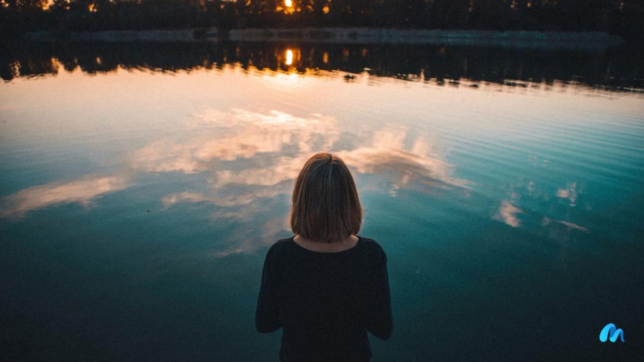 What to do when you feel lost in life? (15 tips) 1 Lost woman with black shirt facing the lake at dawn-what to do when u feel lost in life