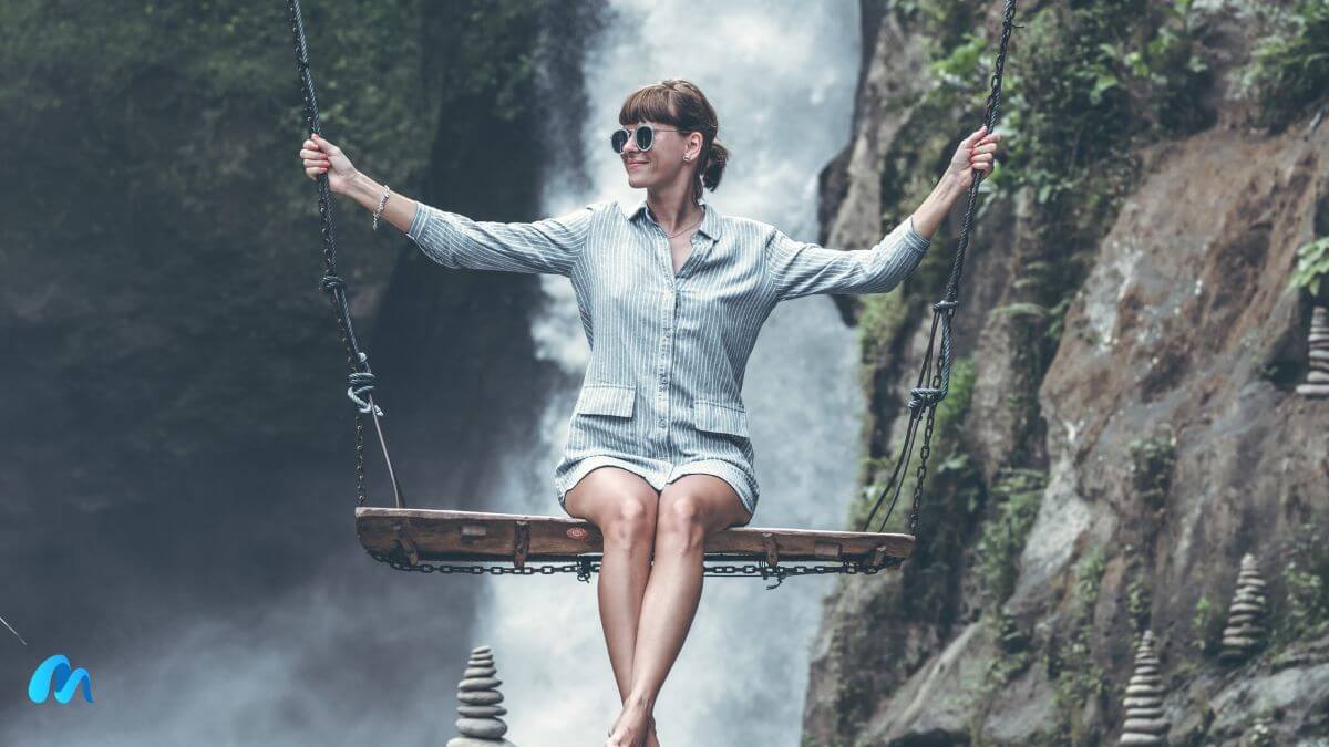 Beautiful woman swings near waterfall in the jungle of bali island-living your truth