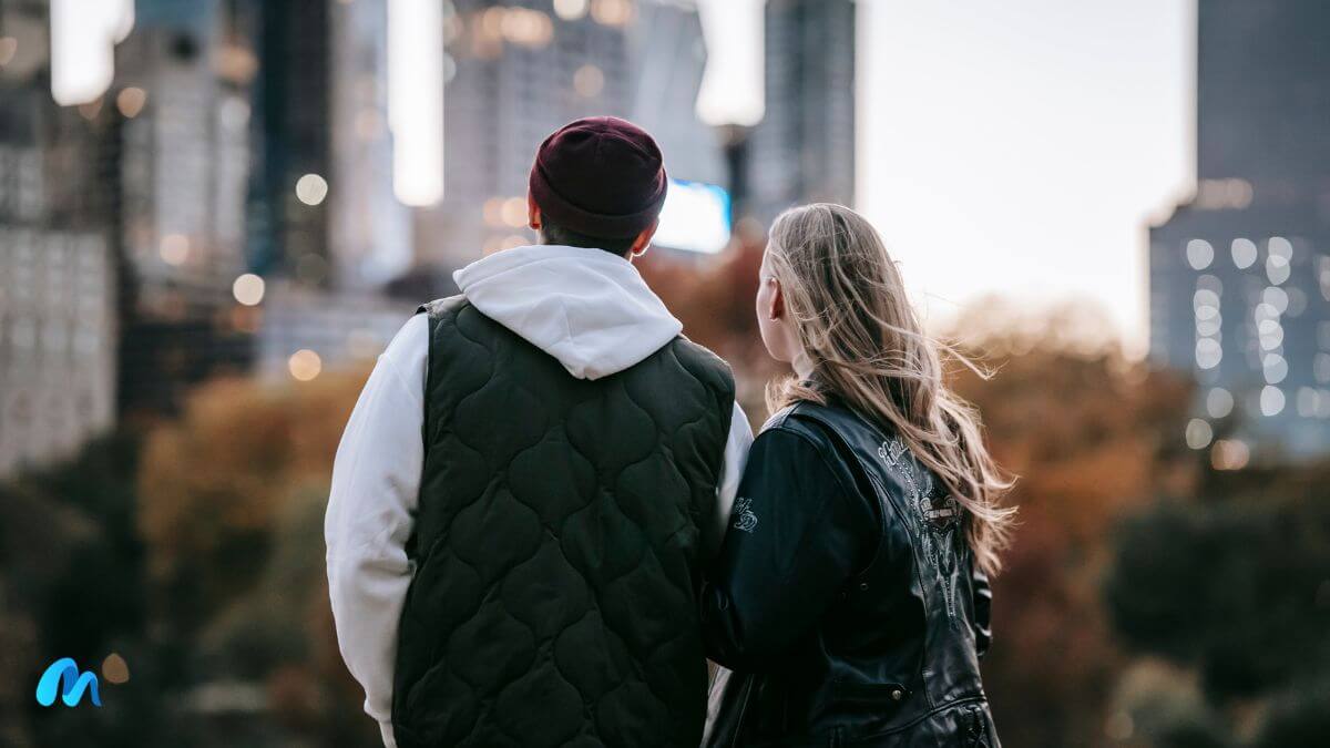 Relationships-young couple looking towards the city landscape on a cold sunny day