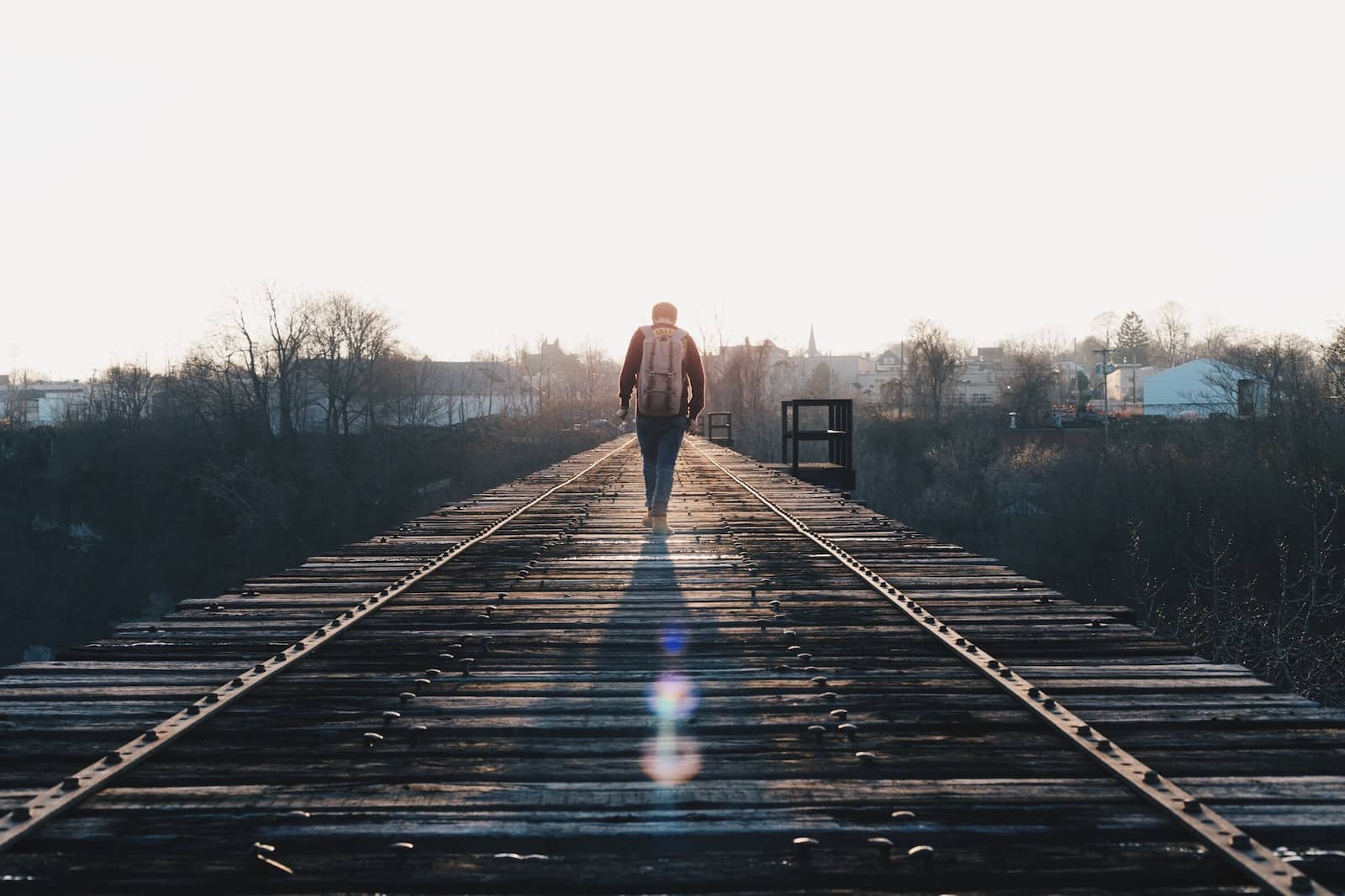 Man walking in the middle of rail road-living away from family