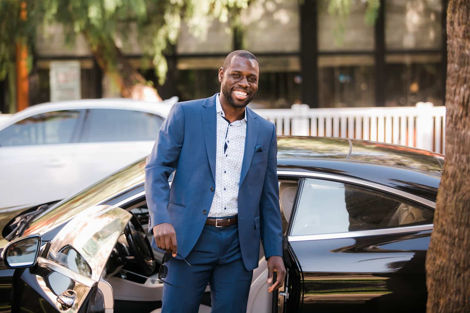 Man in blue suit standing beside black car-powerful success habits