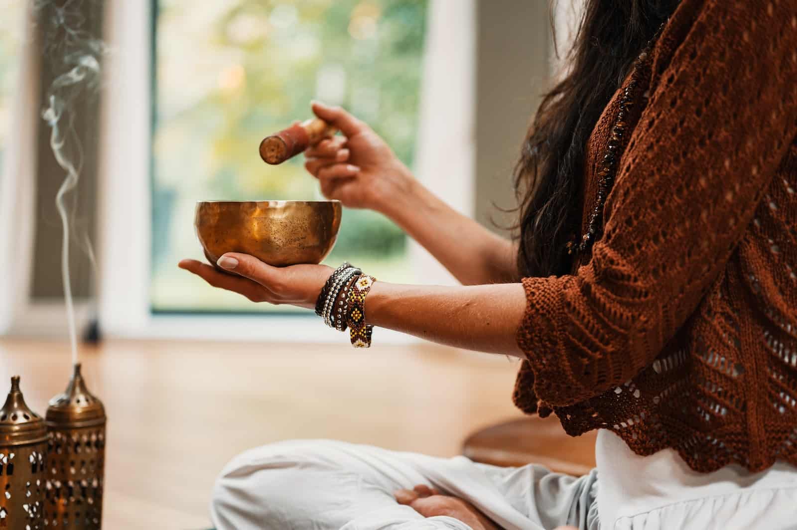 Woman in brown knit sweater holding brown ceramic cup-self care