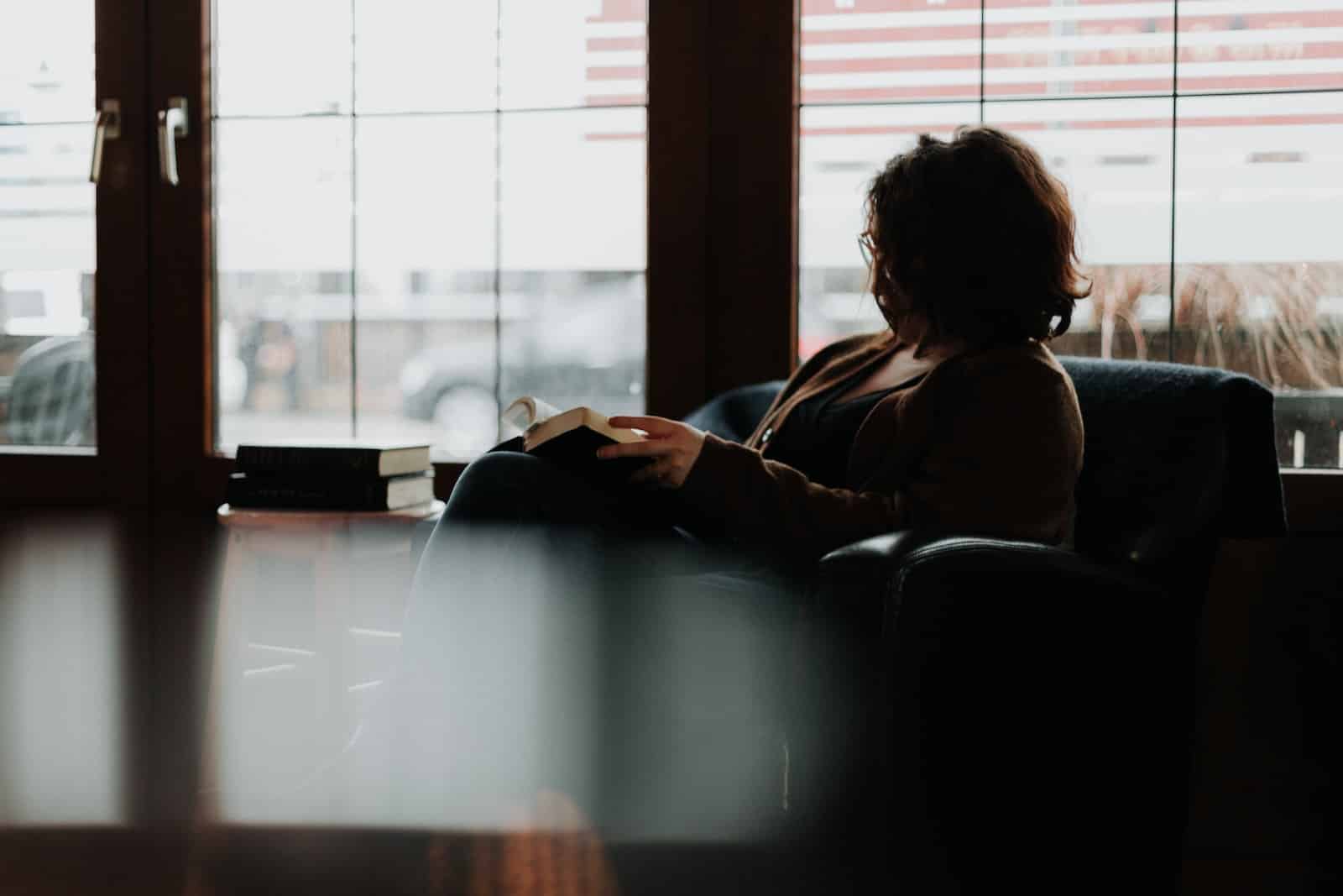 Person in brown jacket sitting on black leather couch-time-worthy