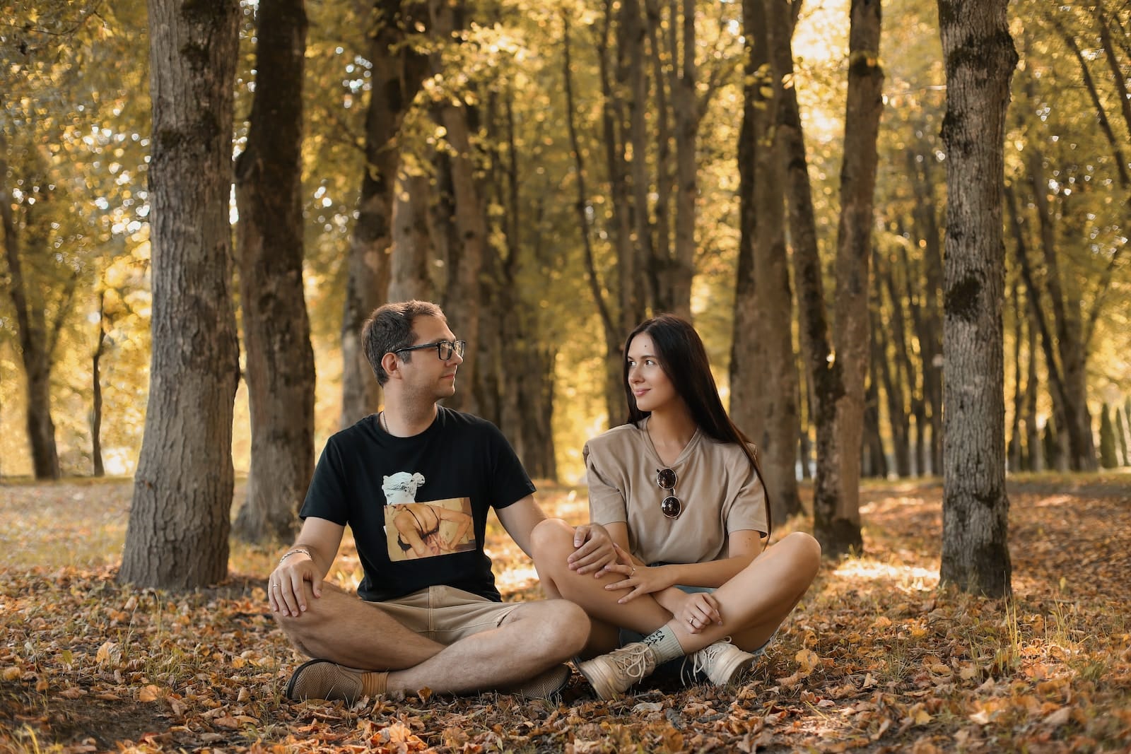 A man and a woman sitting on the ground in a forest-dating a lawyer