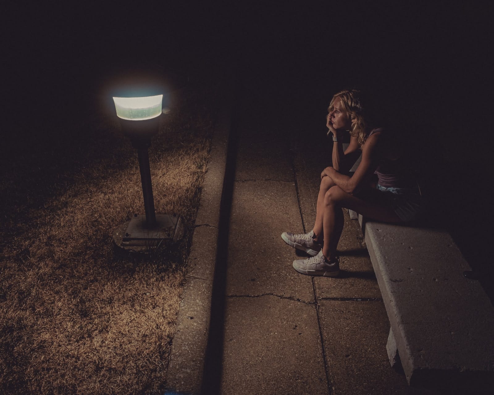 Woman in black tank top sitting on concrete floor-fully love