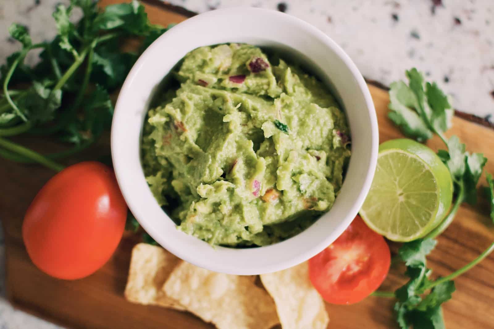 Green soup in white ceramic bowl-guacamole benefits