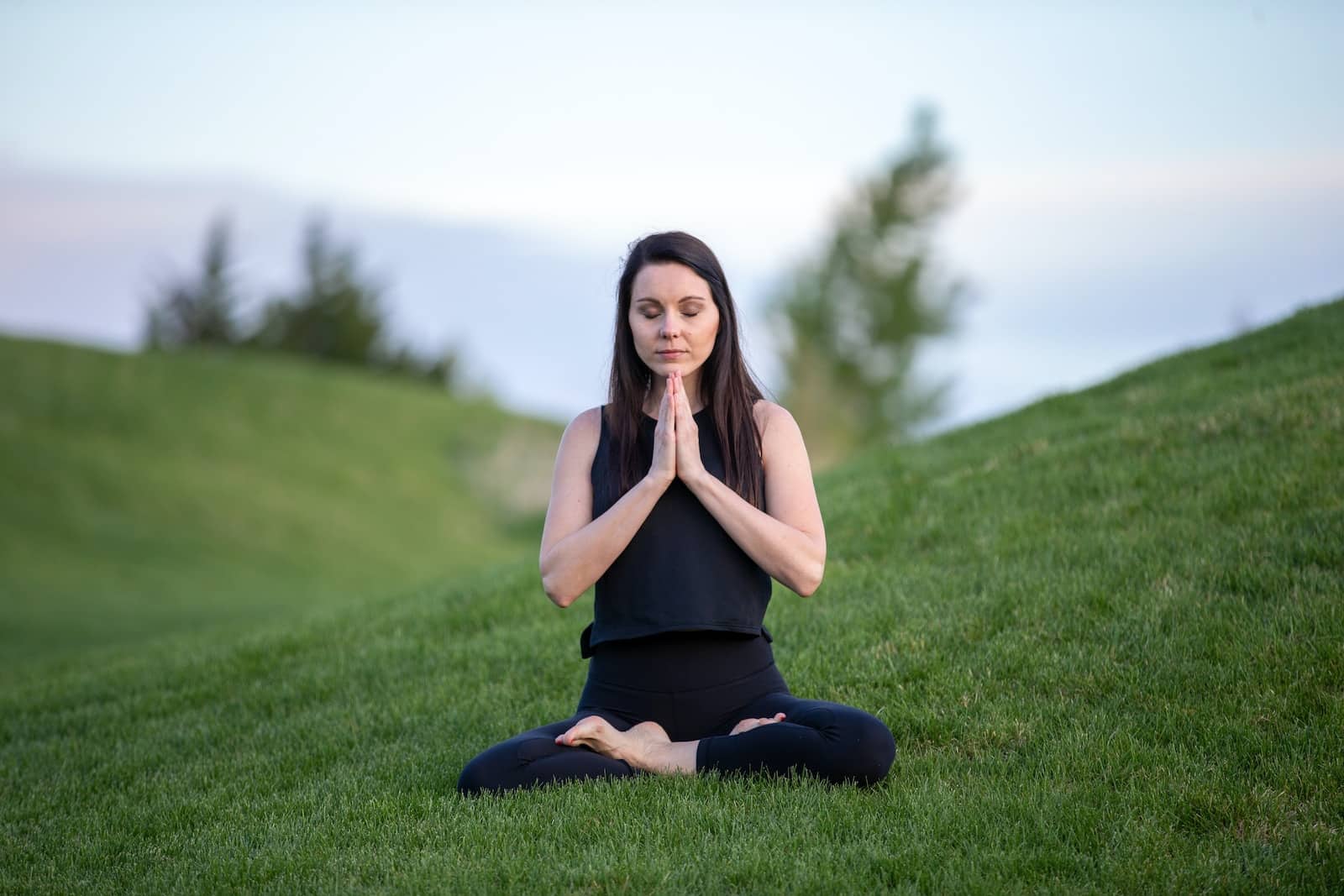 Woman in black tank top and black pants sitting on green grass field during daytime-how to start mindfulness meditation
