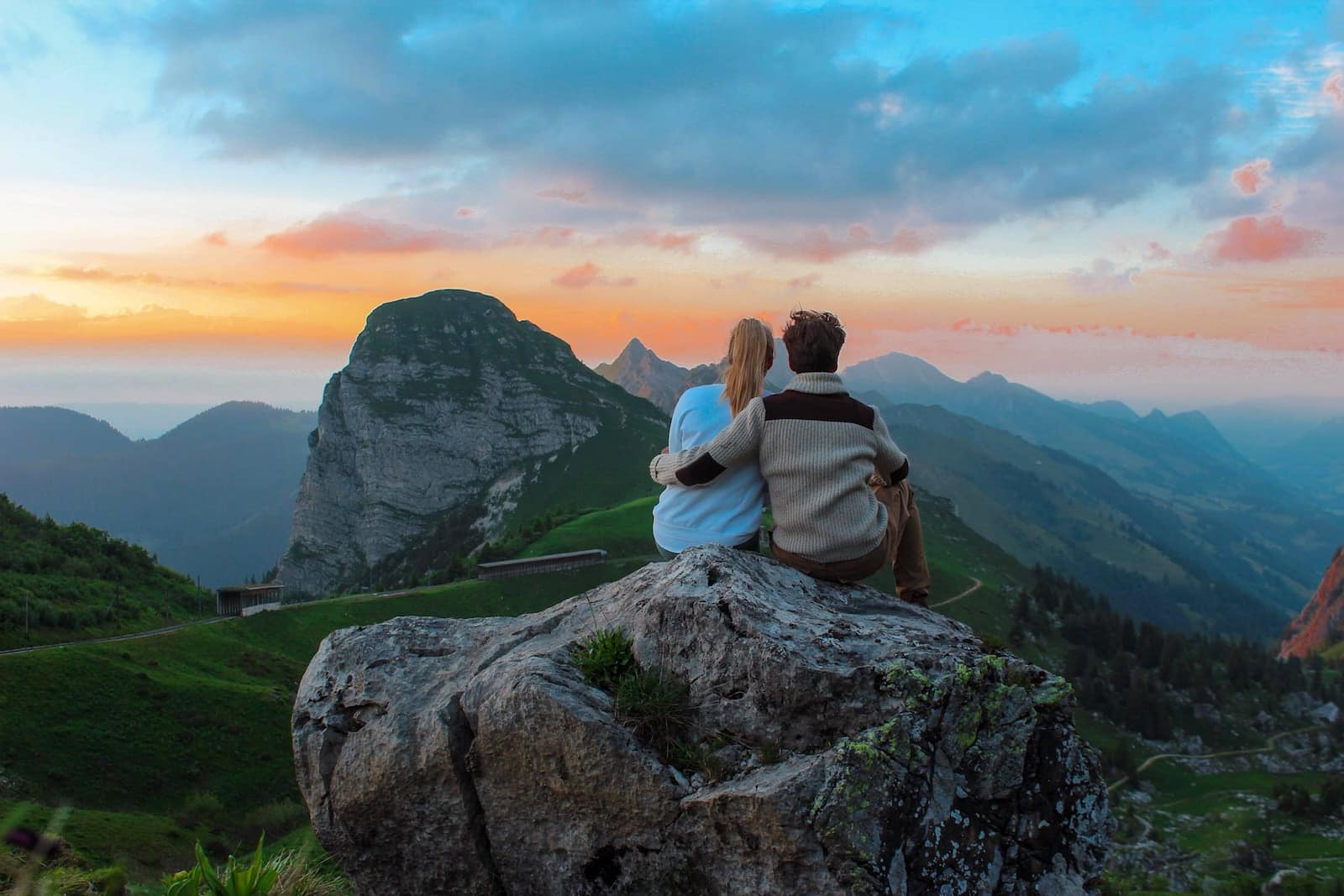 Couple sitting on rock facing mountain view-romance without love