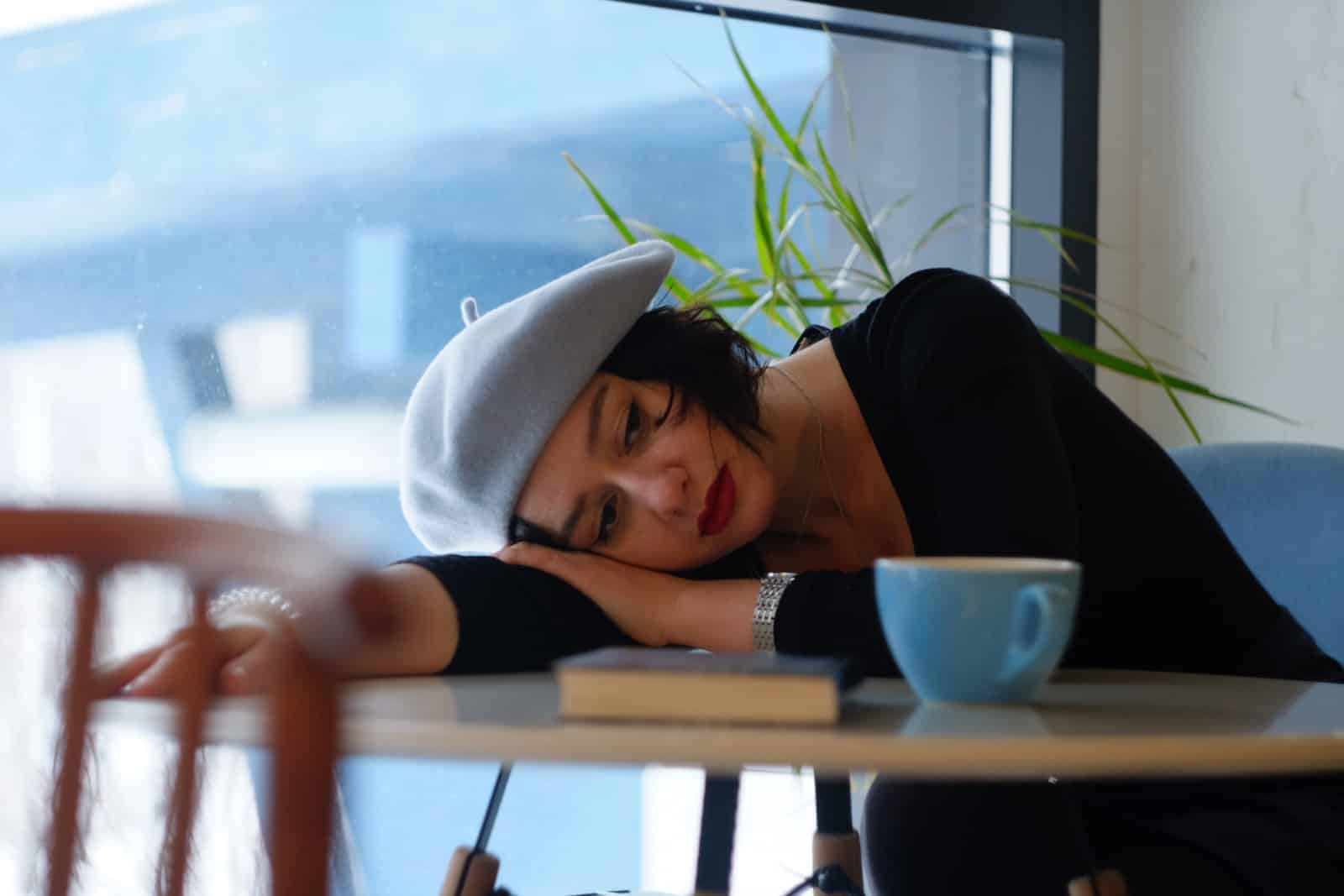 Woman in black long sleeve shirt lying on white wooden table-struggling inside