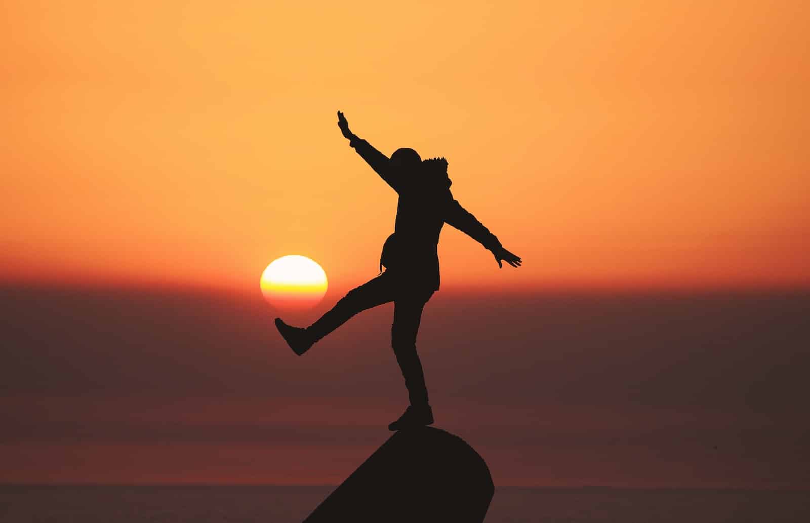 Photo of silhouette photo of man standing on rock-turn negative into positive