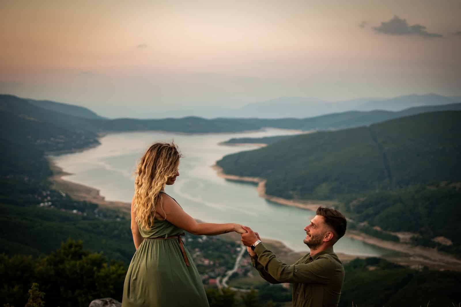 Man and woman standing on top of mountain during daytime