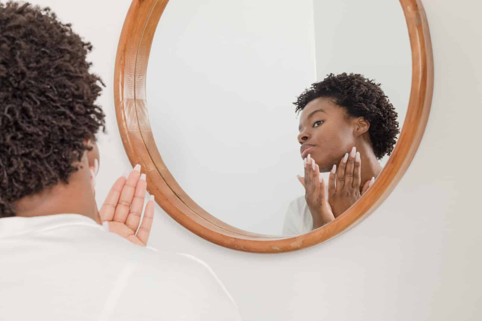 Man wearing white shirt facing on wall mirror-ashwagandha skin benefits