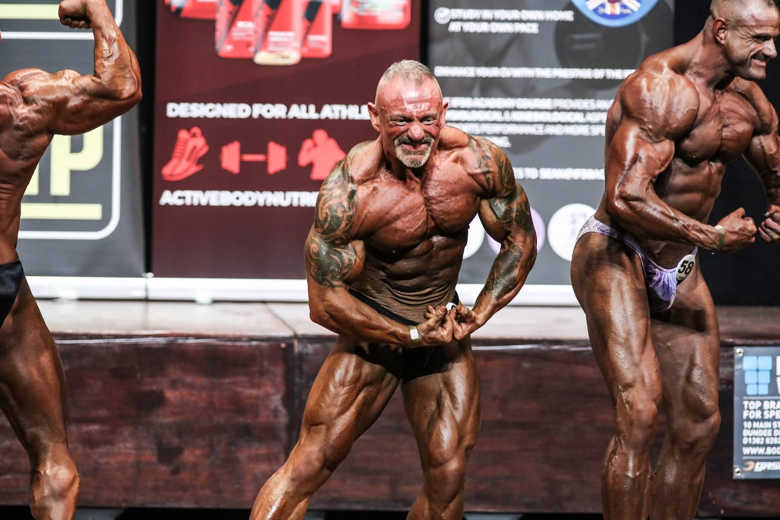 A group of men standing next to each other on a stage-does flexing build muscle