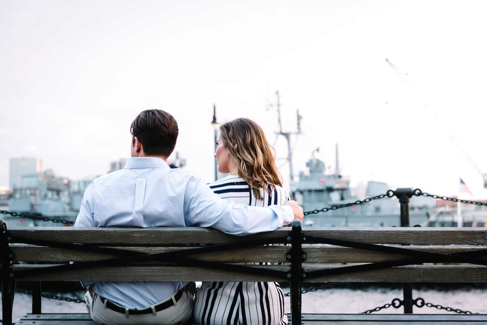 Couple sitting on bench near body of water-benefits of dealing with emotional baggage