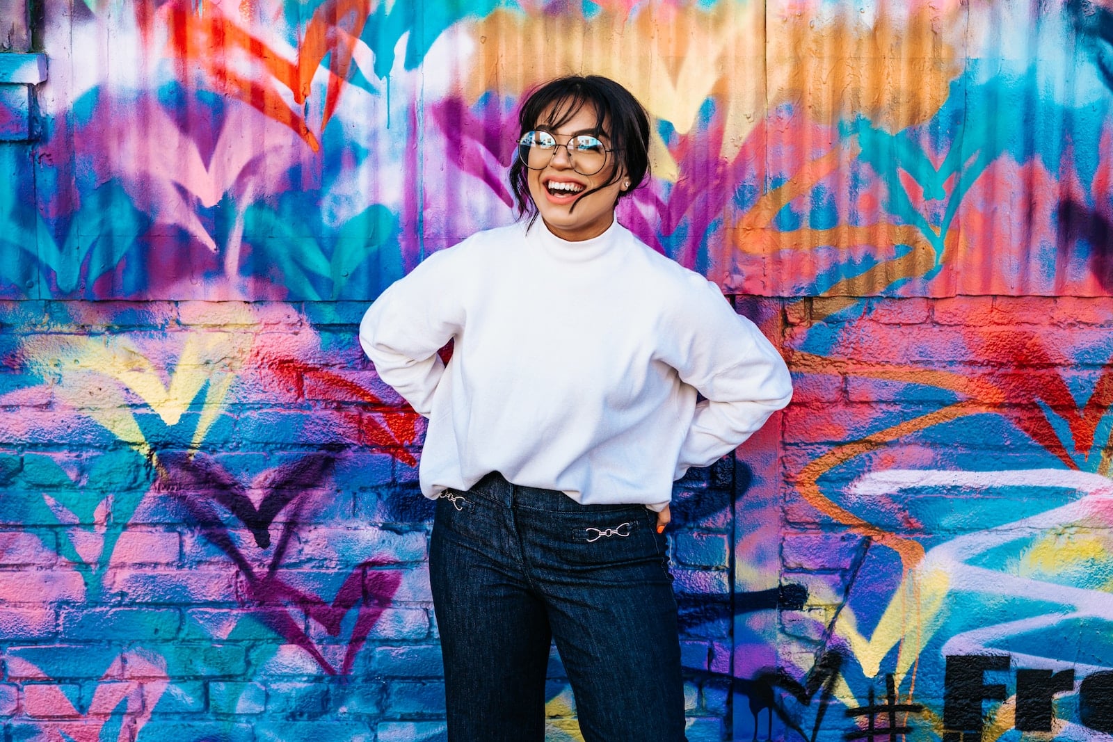 Woman standing in front of multicolored wall-feel joyful today