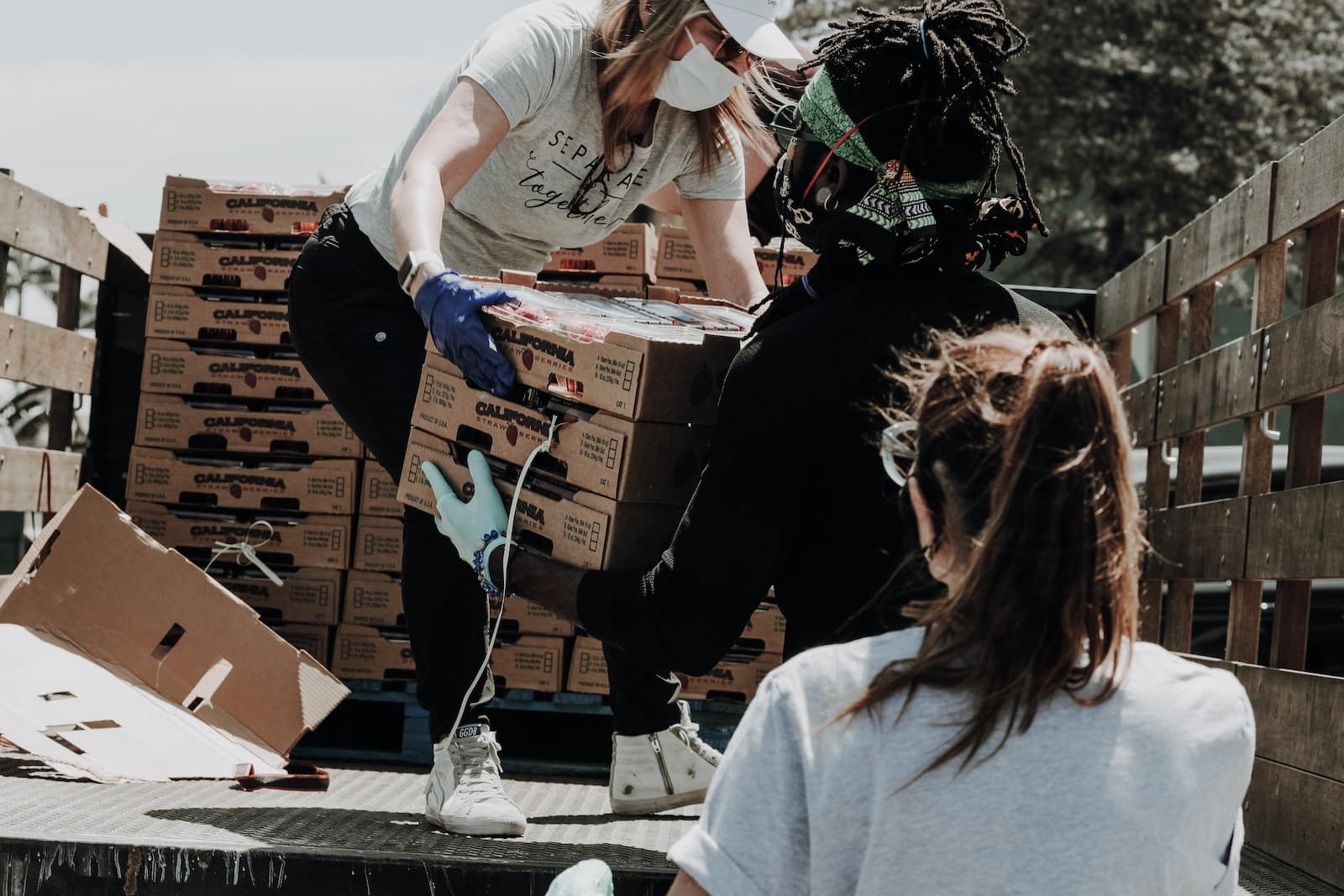 Woman in white t-shirt and blue denim jeans sitting on brown cardboard box-get motivation for volunteering