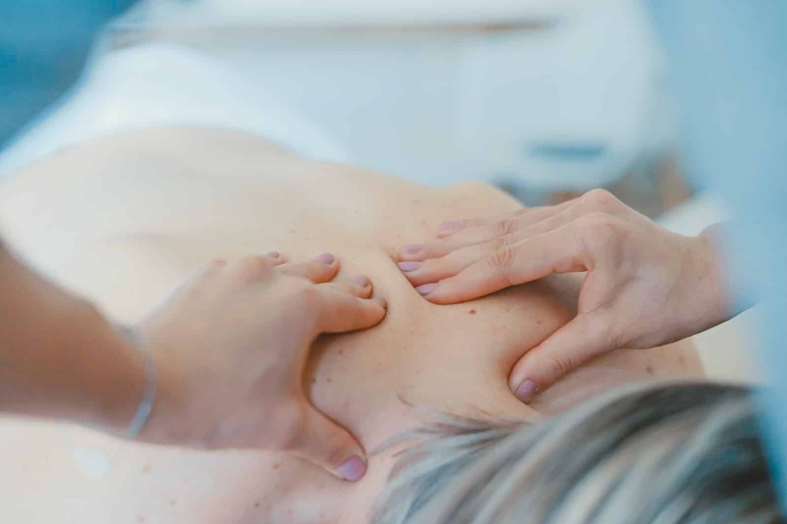 Person massaging the back of a woman-benefits of massage therapy