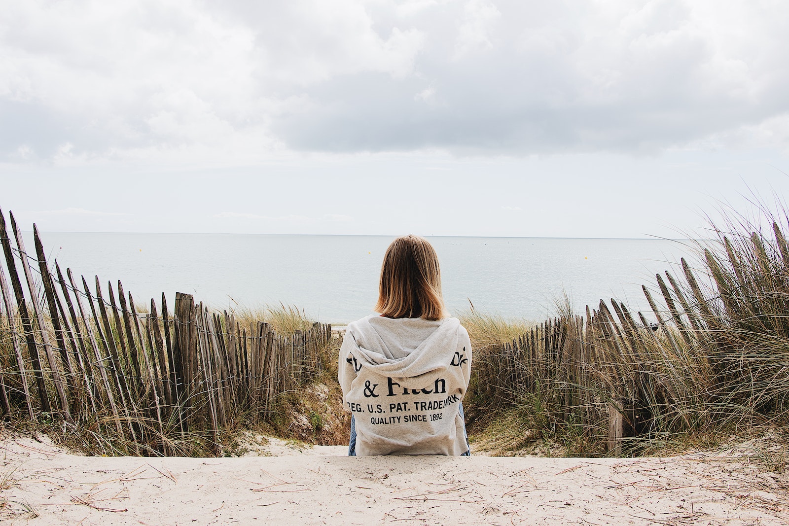 Woman sitting near plants and fence-do rebound relationships really make you miss your ex more