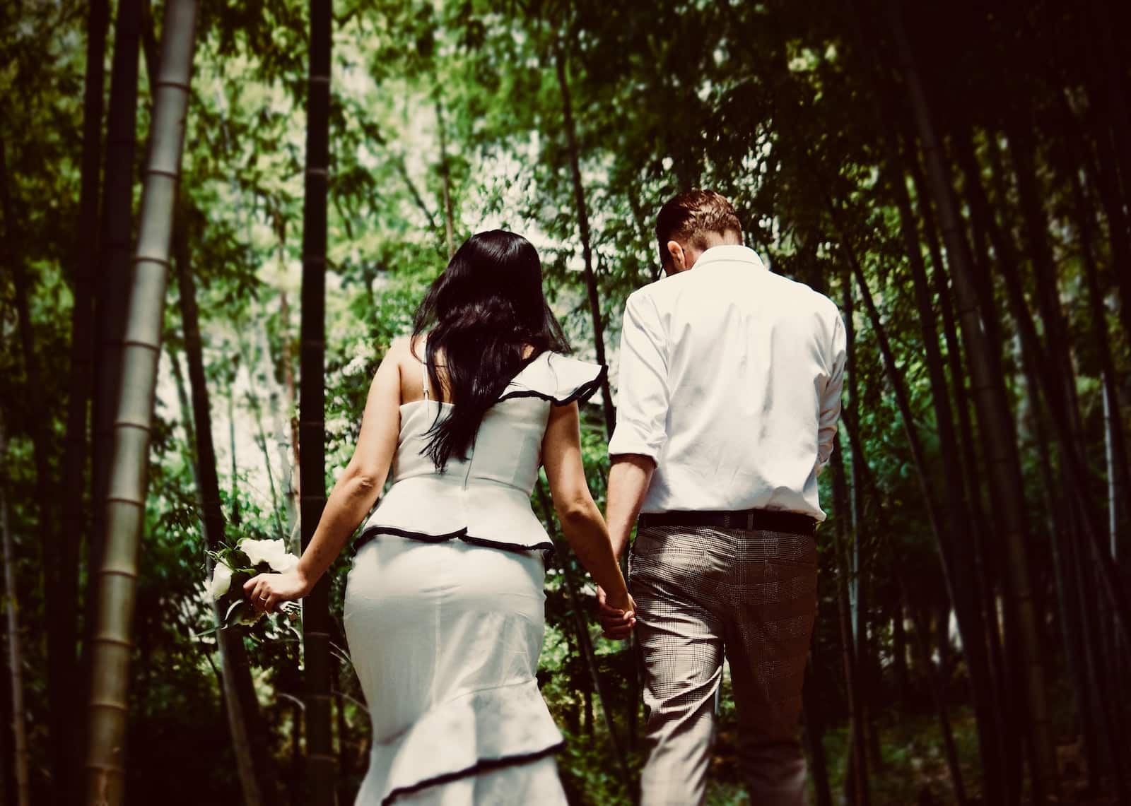 Man and woman holding hands while walking near trees-falling for your type