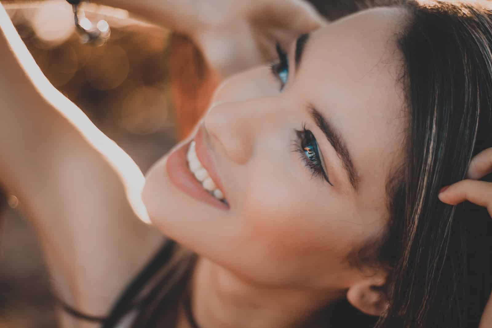 Smiling woman with black hair and red lipstick-quinoa oil benefits for skin