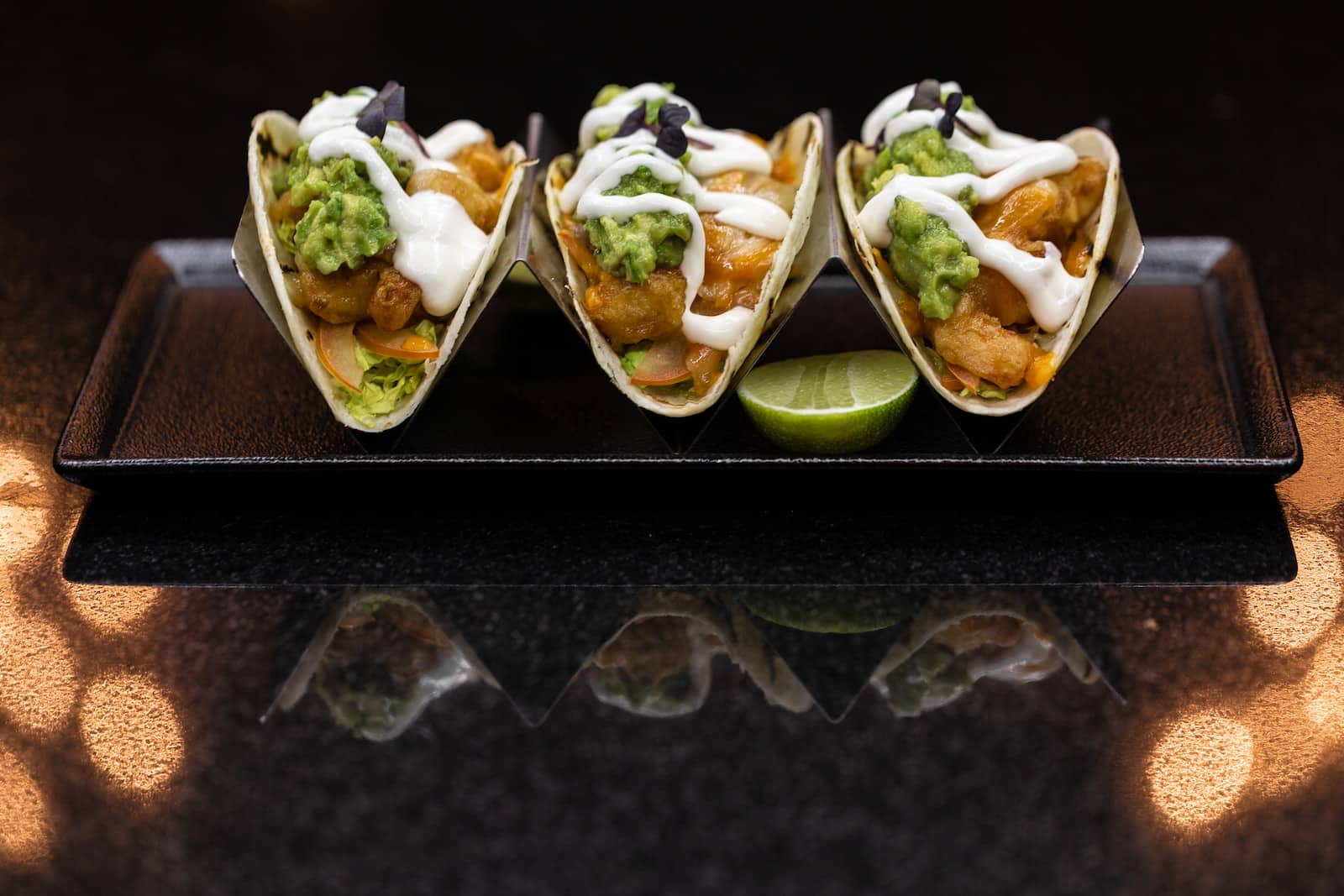 Green and white dish on black ceramic tray-is a taco a sandwich