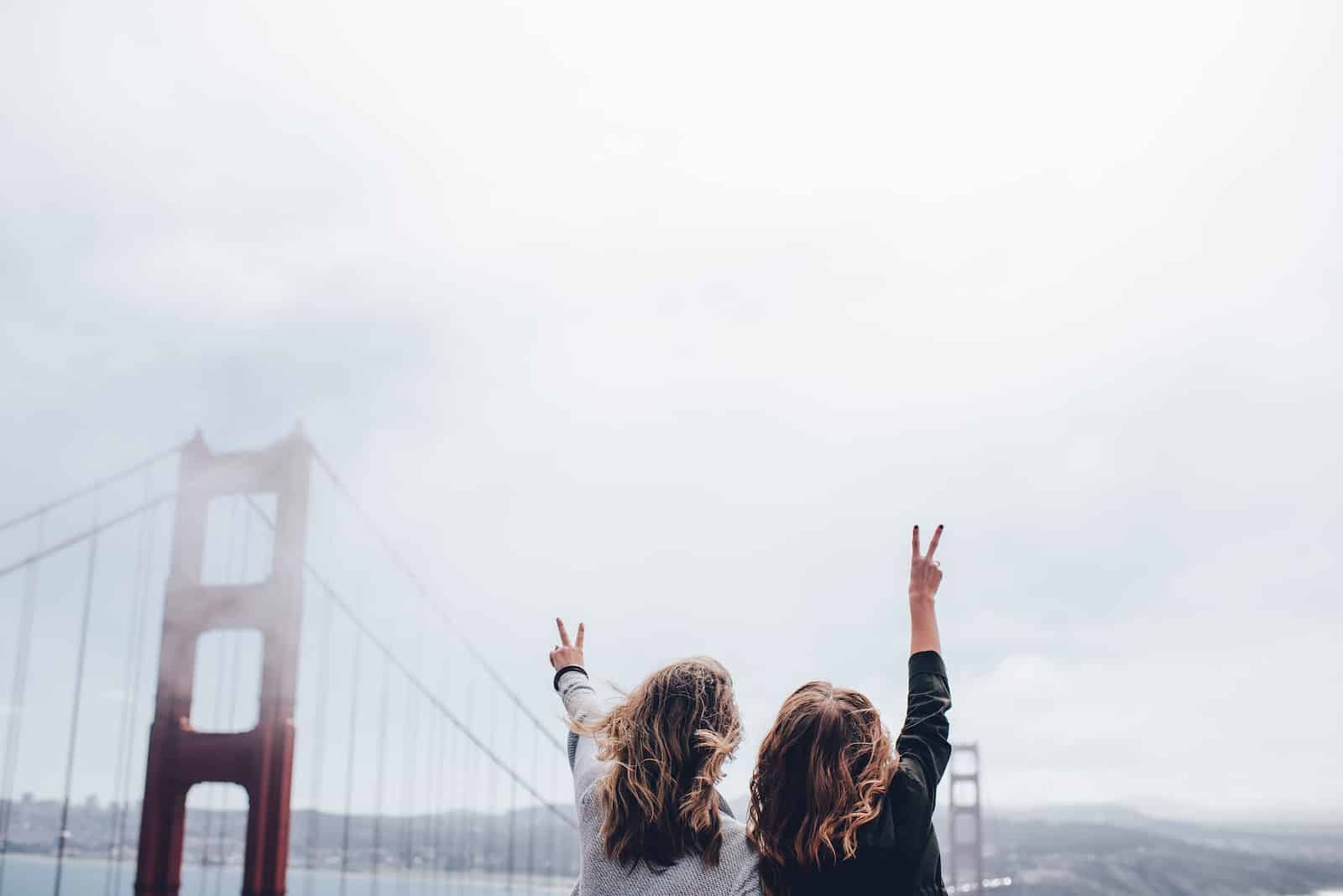 Two women making peace sign near the golden gate bridge-why friends come and go