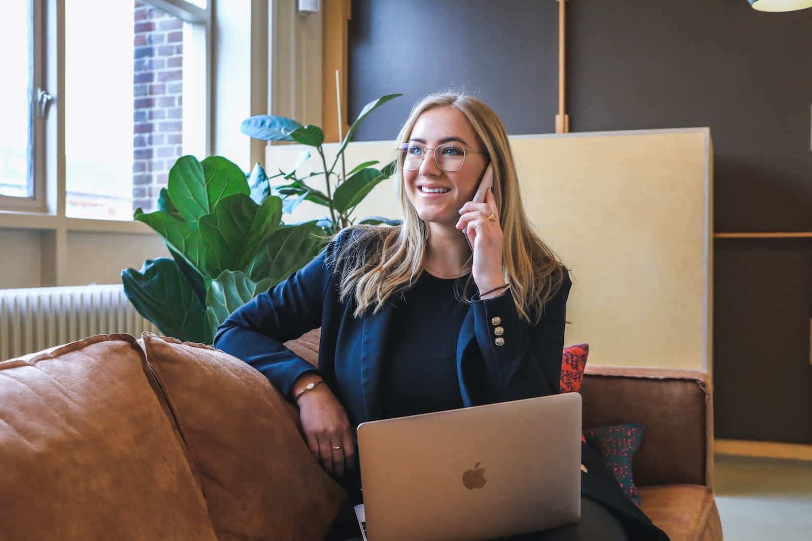 Woman in blue long sleeve shirt using silver macbook-returning to the office is killing my budget
