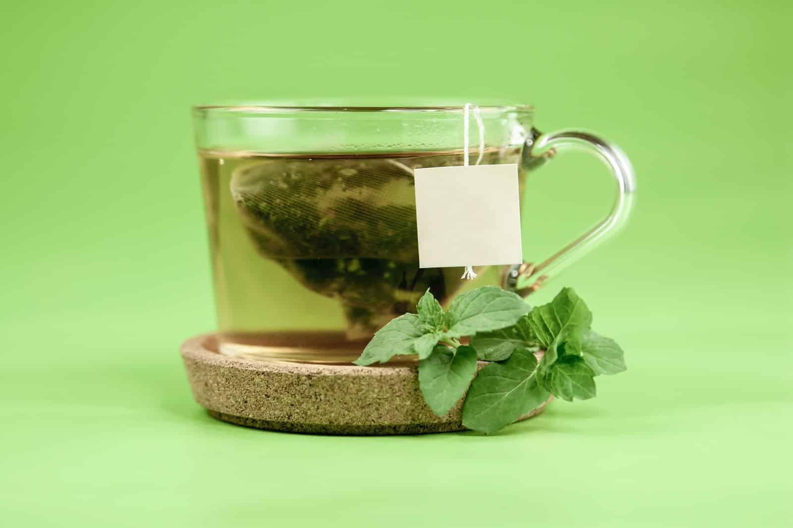 Clear glass mug with green leaves-green tea