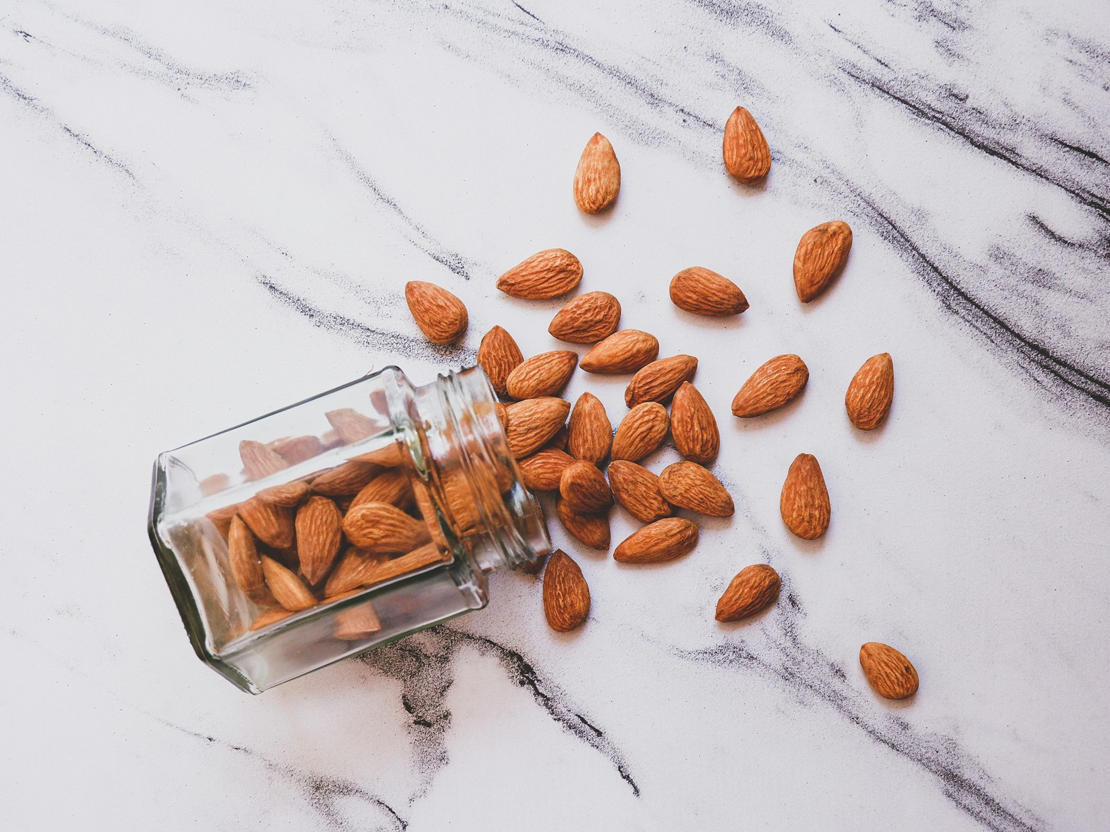 Brown almond on white table-does almond milk make you poop